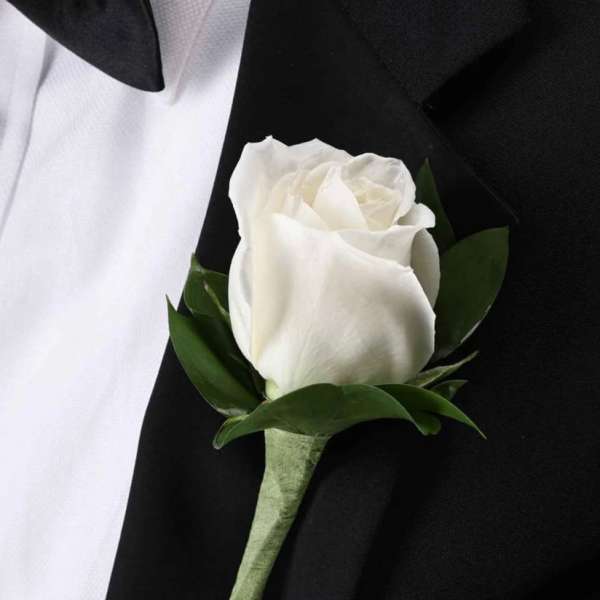 White rose boutonniere on a black suit jacket