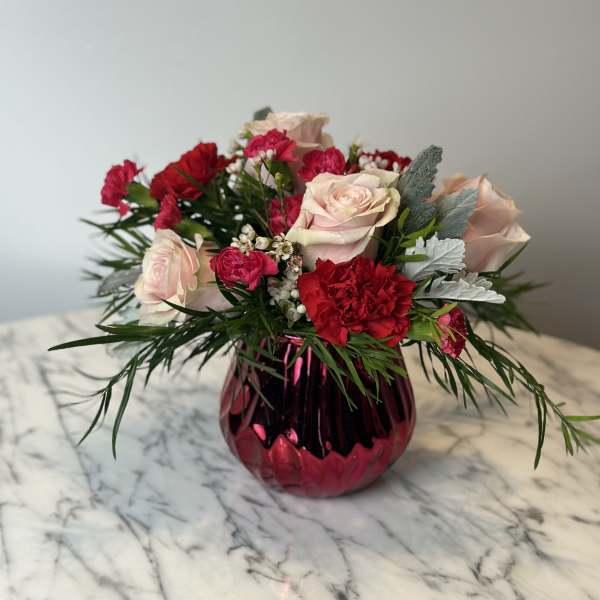 Pink roses and red carnations in a magenta glass vase