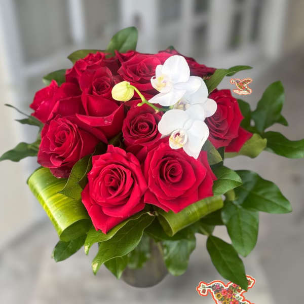 Red roses with white orchids in a glass vase
