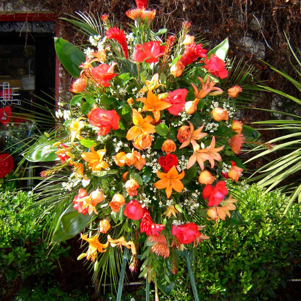 Large tropical standing spray with orange and red flowers