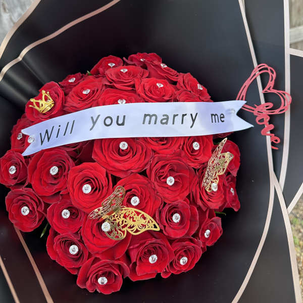 Red rose bouquet with a "Will you marry me" ribbon