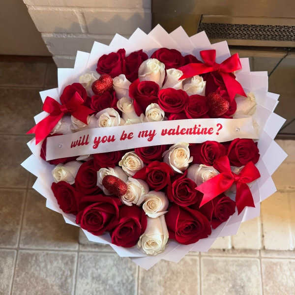 Heart-shaped bouquet of red and white roses with a Valentine ribbon