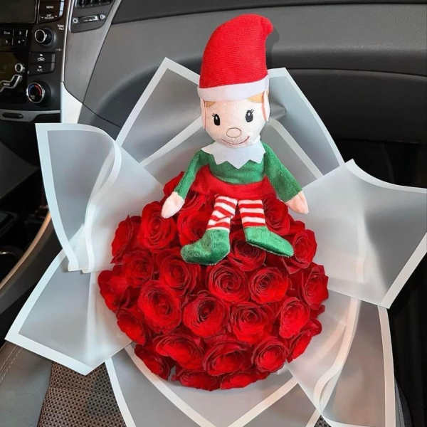 Red rose bouquet with a small elf doll on top