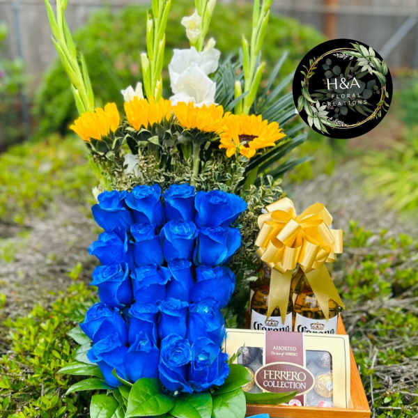 Blue roses with yellow flowers and chocolates in a gift basket
