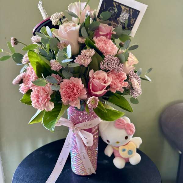 Pink bouquet in a sparkly vase with a Hello Kitty plush