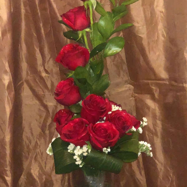 Tall bouquet of red roses in a clear glass vase