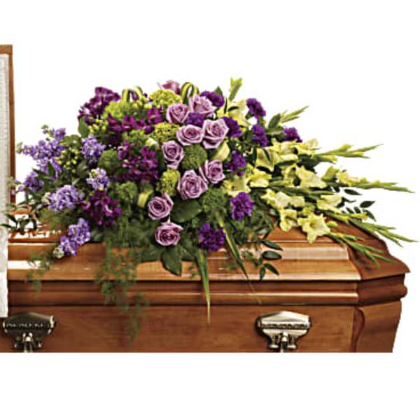 Purple and yellow floral spray on a wooden casket