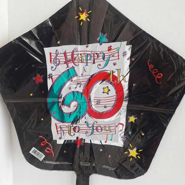 Black 60th birthday foil balloon with colorful music notes and stars