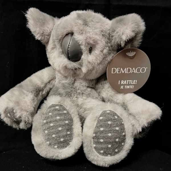 Gray plush koala bear with a hanging tag on a black background