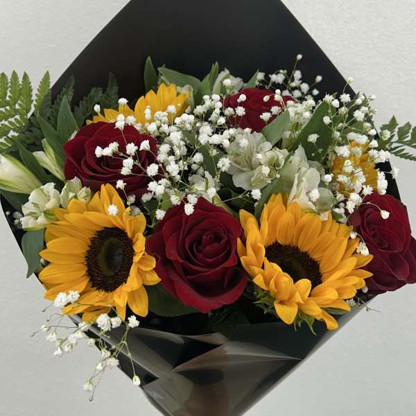 Bouquet of red roses and yellow sunflowers with white filler flowers