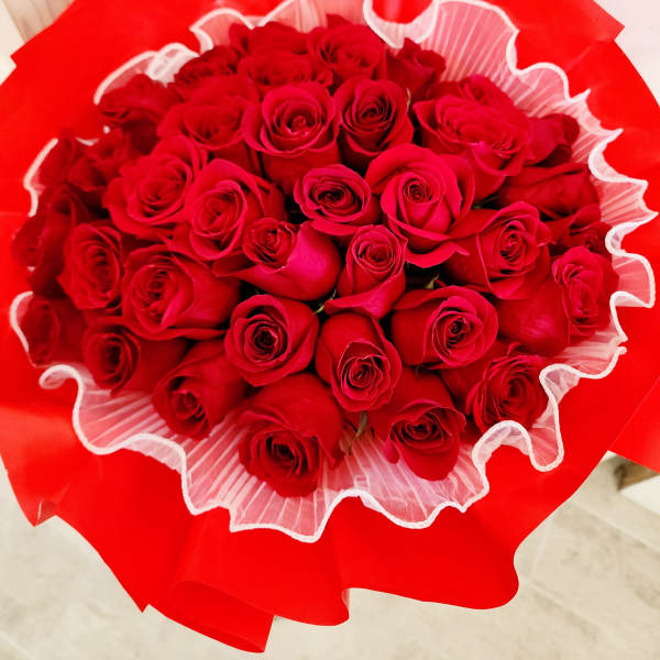 Bouquet of red roses wrapped in bright red paper