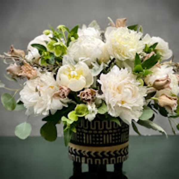 White floral arrangement in a patterned black vase