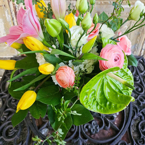 Mixed bouquet with pink and yellow tulips, pink ranunculus, and white blooms