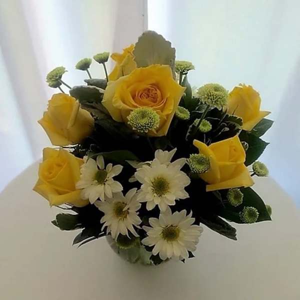 Yellow roses and white daisies in a compact bouquet