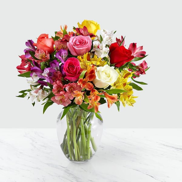Mixed bouquet of roses and alstroemeria in a clear glass vase