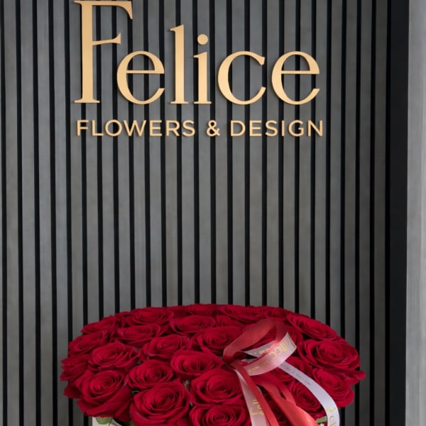 Round box of red roses with a ribbon bow