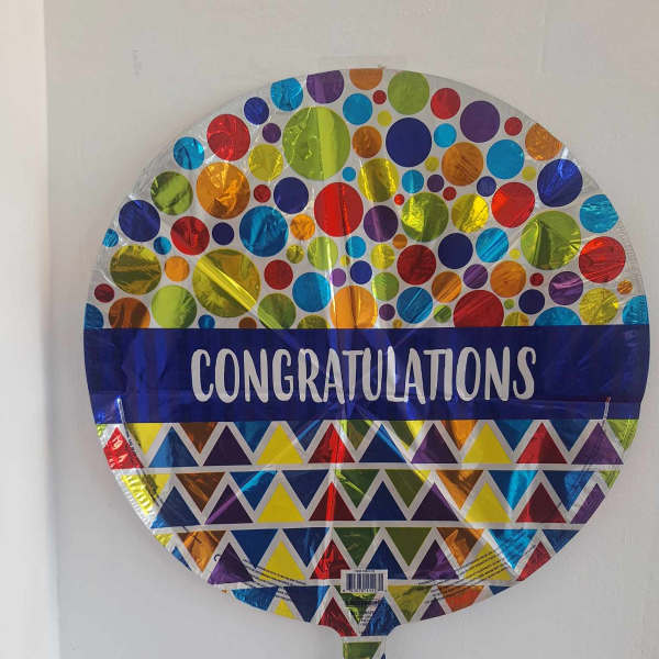 Round foil balloon with colorful dots and the word Congratulations