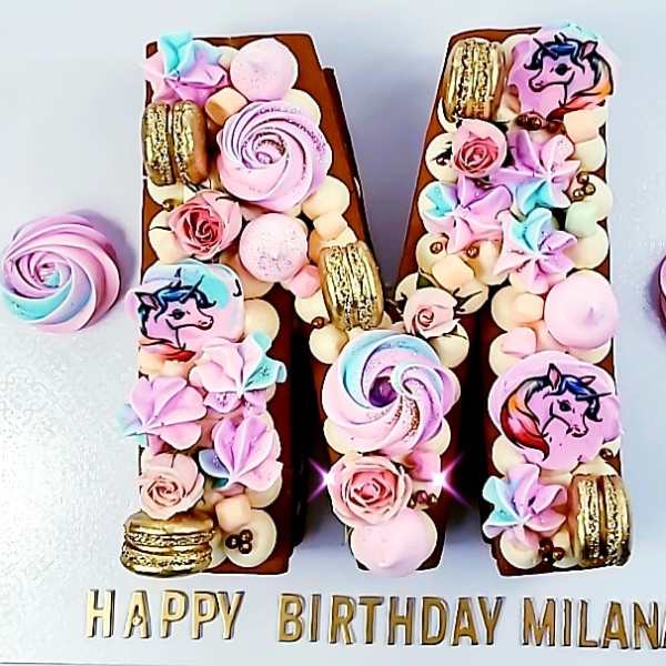 Birthday cake decorated with pastel unicorn and candy toppers