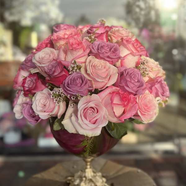 Pink and lavender rose bouquet in a gold pedestal vase