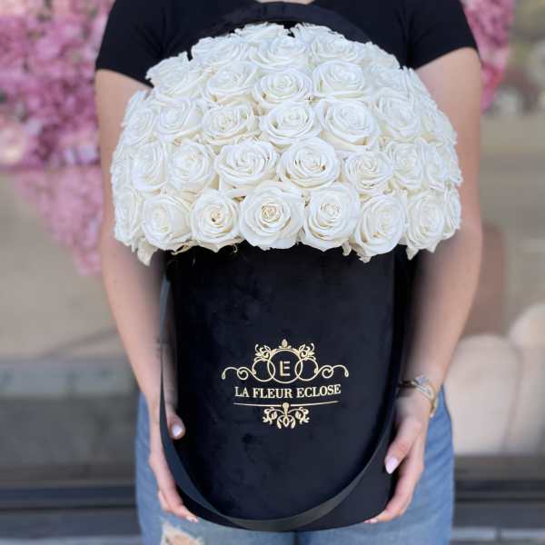 Large bouquet of white roses in a black hatbox