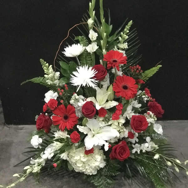 Tall red, white, and green floral spray with roses and lilies
