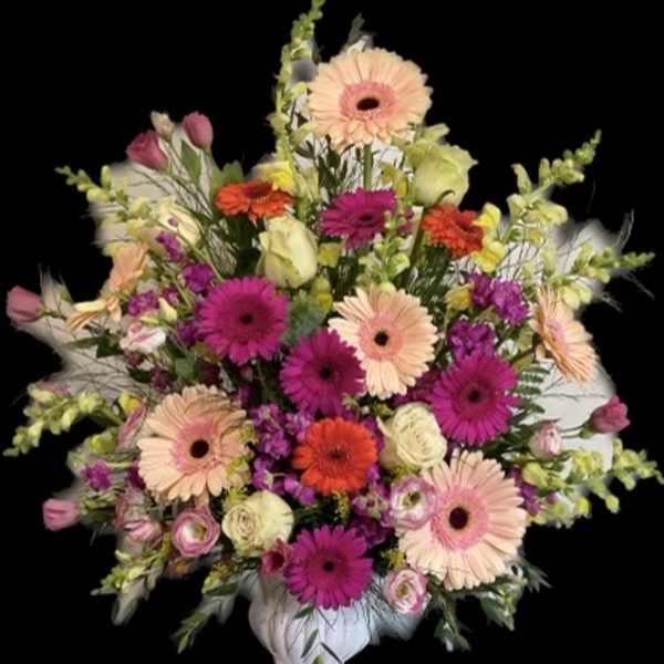 Colorful mixed flower arrangement in a white vase
