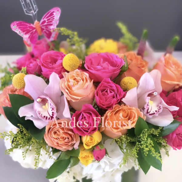 Bright pink and peach rose arrangement with orchids in a square vase
