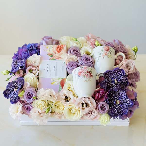 Floral gift box with pastel roses, orchids, and two floral mugs