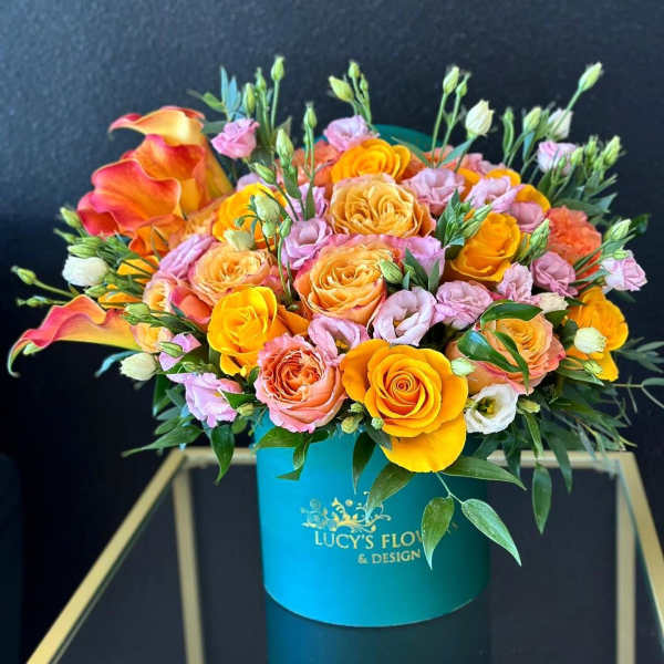 Bouquet of orange and pink roses with calla lilies in a turquoise box