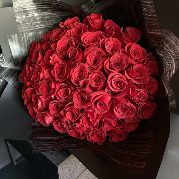 Bouquet of red roses wrapped in black paper