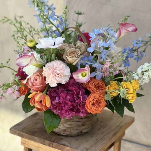 Colorful mixed flower arrangement in a woven basket