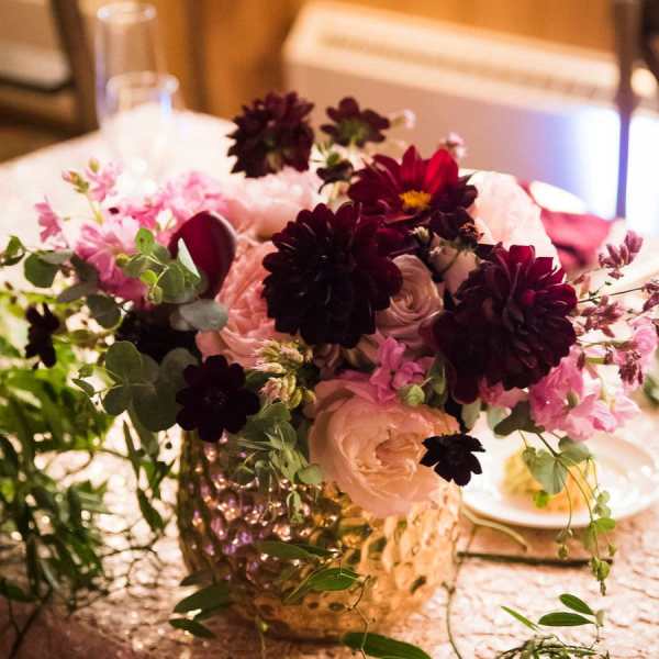Bouquet of dark burgundy and blush flowers in a glass vase