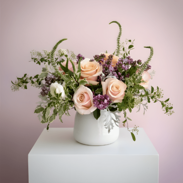 Peach roses and purple flowers in a white vase