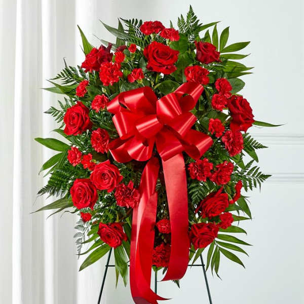Red rose and carnation standing wreath with a large red bow