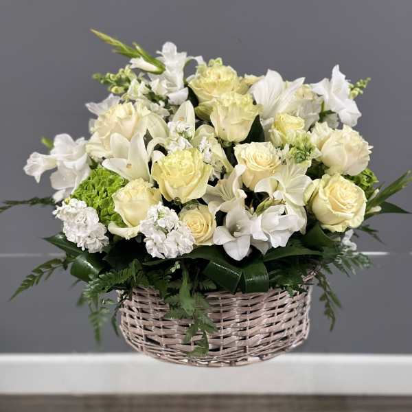 White and cream floral arrangement in a wicker basket