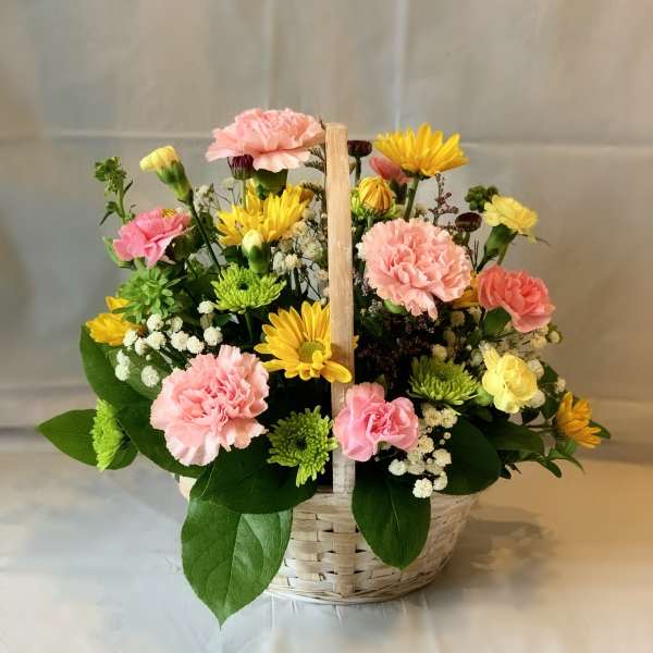 Basket arrangement of pink carnations and yellow daisies