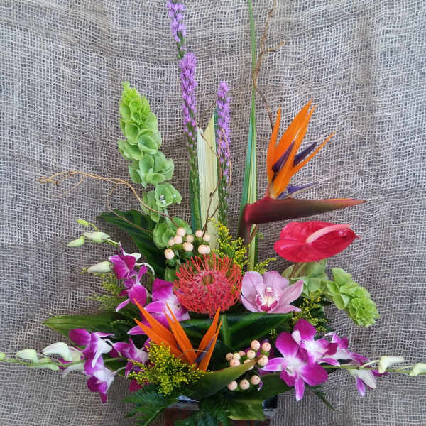 Tropical flower arrangement in a decorative square vase