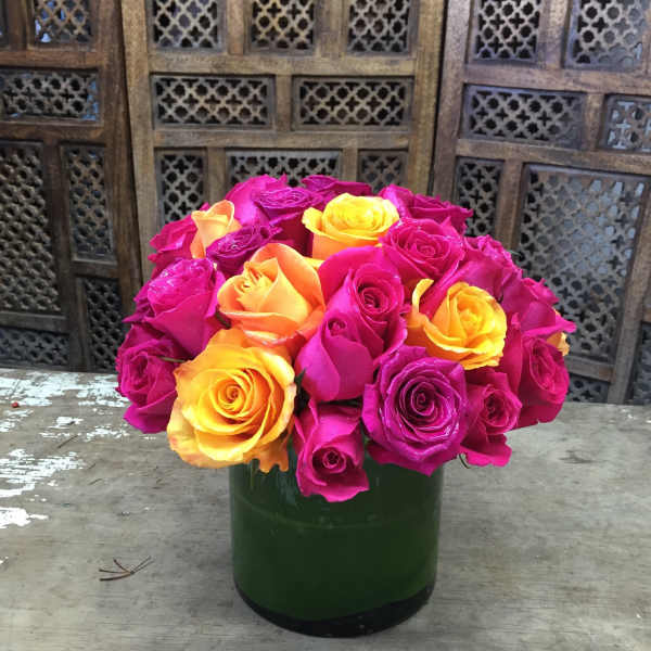 Bouquet of pink, yellow, and orange roses in a green vase
