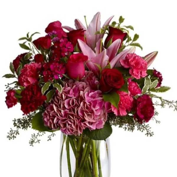 Bouquet of pink and red flowers in a clear glass vase