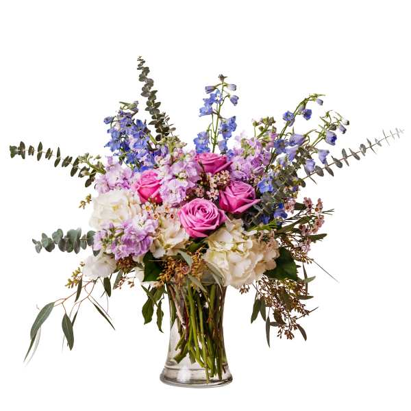 Pink roses and lavender flowers in a clear glass vase