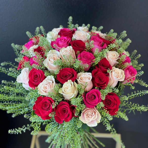 Bouquet of red, pink, and blush roses with airy greenery