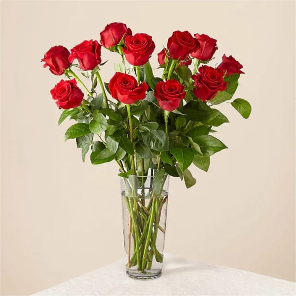 Red roses arranged in a clear glass vase