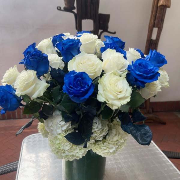 Blue and white roses arranged in a green vase
