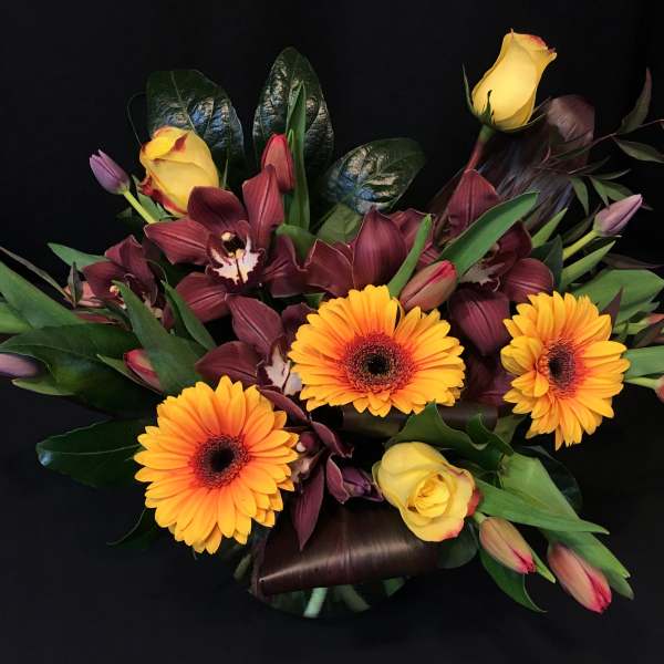 Bouquet of yellow roses, orange gerbera daisies, and burgundy orchids