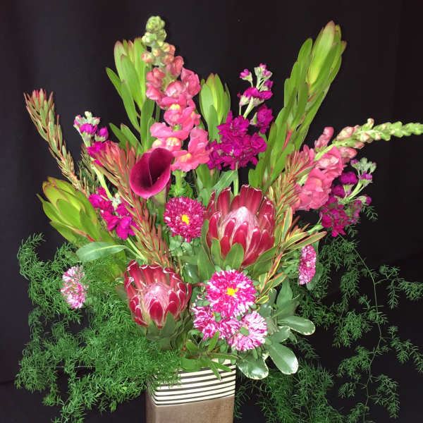 Tall floral arrangement with pink and magenta blooms in a rectangular vase