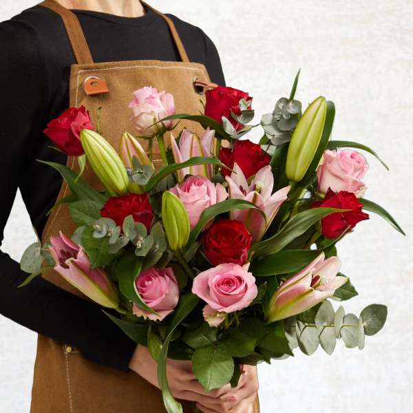 Bouquet of pink and red roses with lilies and eucalyptus