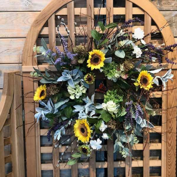 Sunflower wreath with purple accents on a wooden chair back