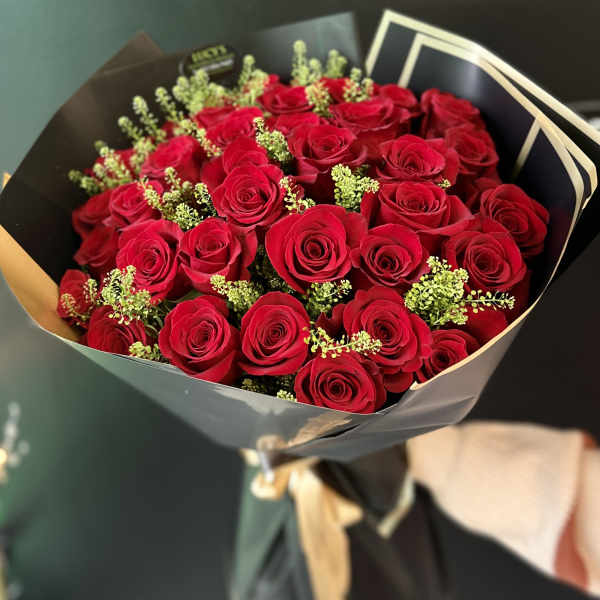 Bouquet of red roses wrapped in black paper