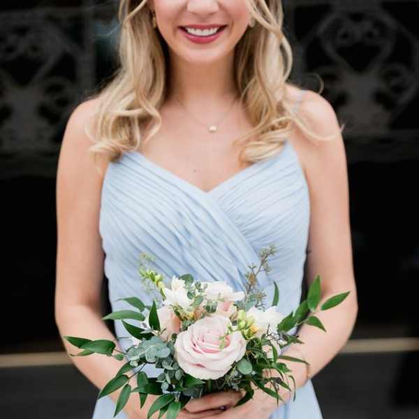 Woman holding a pale pink and white bridal bouquet