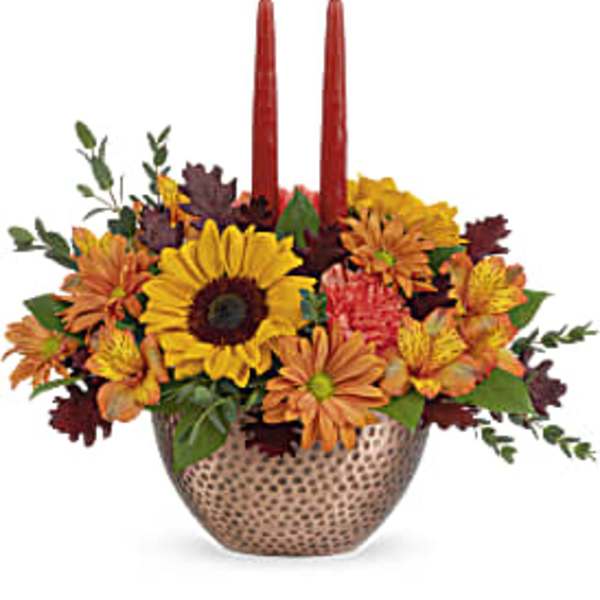 Autumn floral centerpiece with two red taper candles in a patterned vase